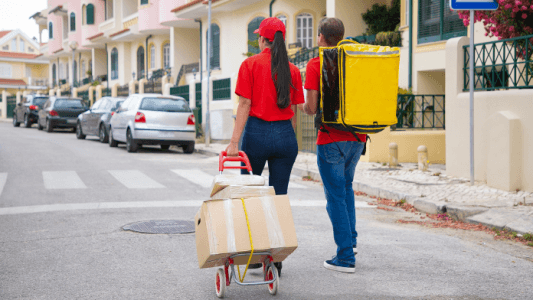 two-post-office-workers-with-yellow-thermal-bag-boxes-trolley-back-view-couriers-red-shirts-looking-address-delivering-order-delivery-service-online-shopping-concept